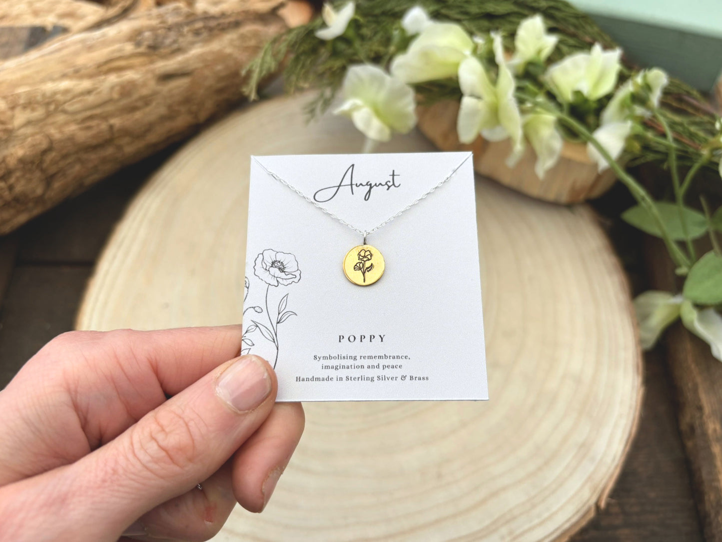Gold necklace on a card held by a hand with a natural background