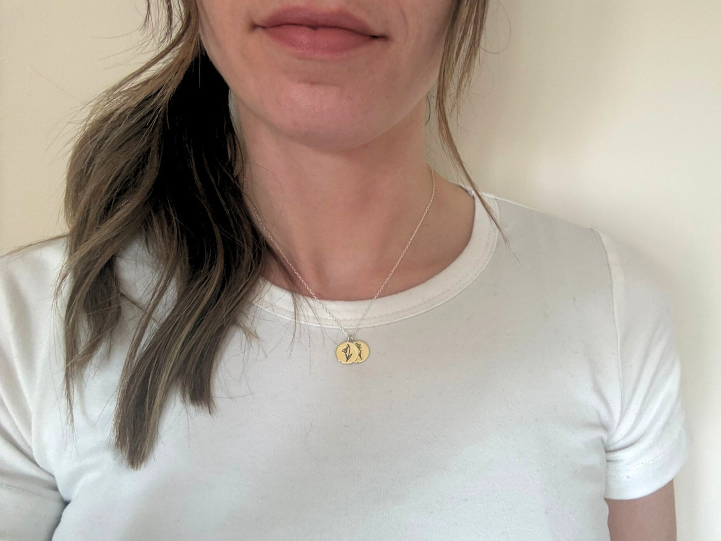 Brass birth flower bouquet necklace by curious magpie jewellery featuring charms on a necklace with engraved birth flowers on each charm.