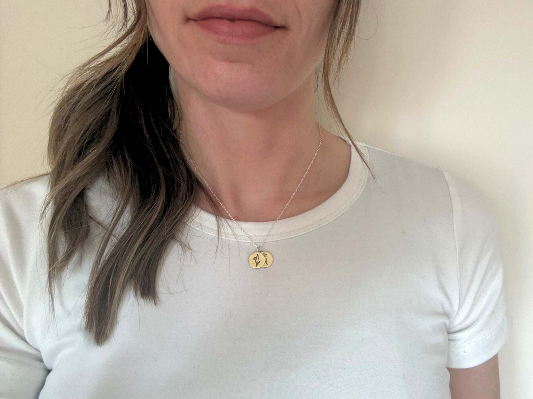 Brass birth flower bouquet necklace by curious magpie jewellery featuring charms on a necklace with engraved birth flowers on each charm.