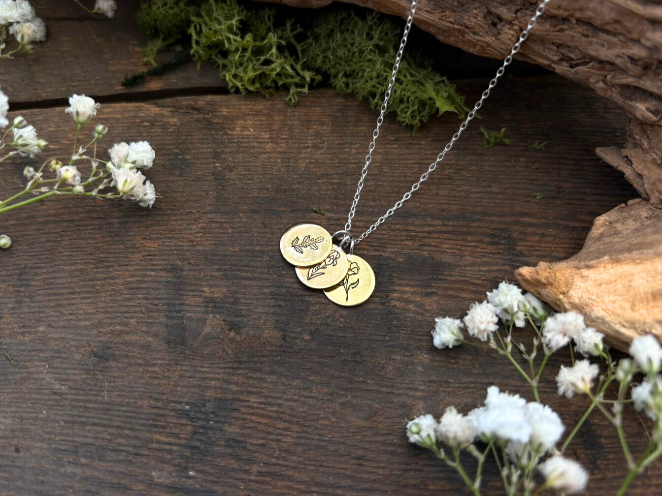 Brass birth flower bouquet necklace by curious magpie jewellery featuring charms on a necklace with engraved birth flowers on each charm.