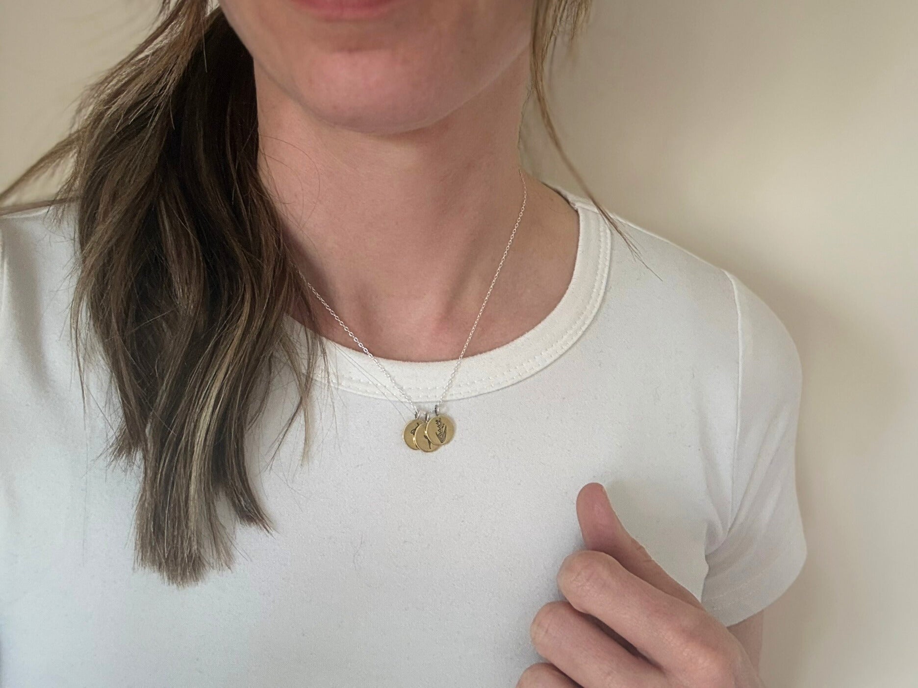 Brass birth flower bouquet necklace by curious magpie jewellery featuring charms on a necklace with engraved birth flowers on each charm.