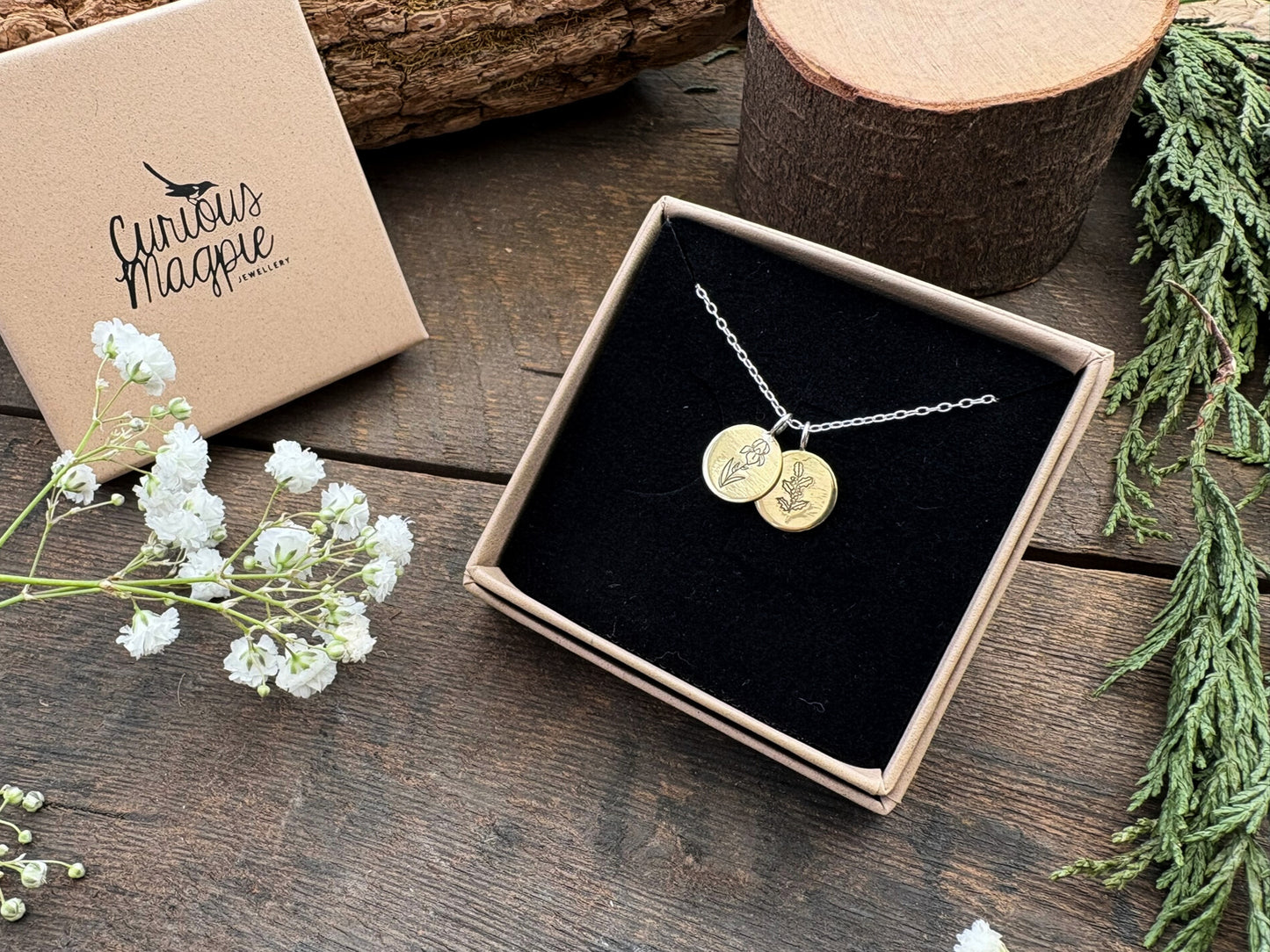Brass birth flower bouquet necklace by curious magpie jewellery featuring charms on a necklace with engraved birth flowers on each charm.