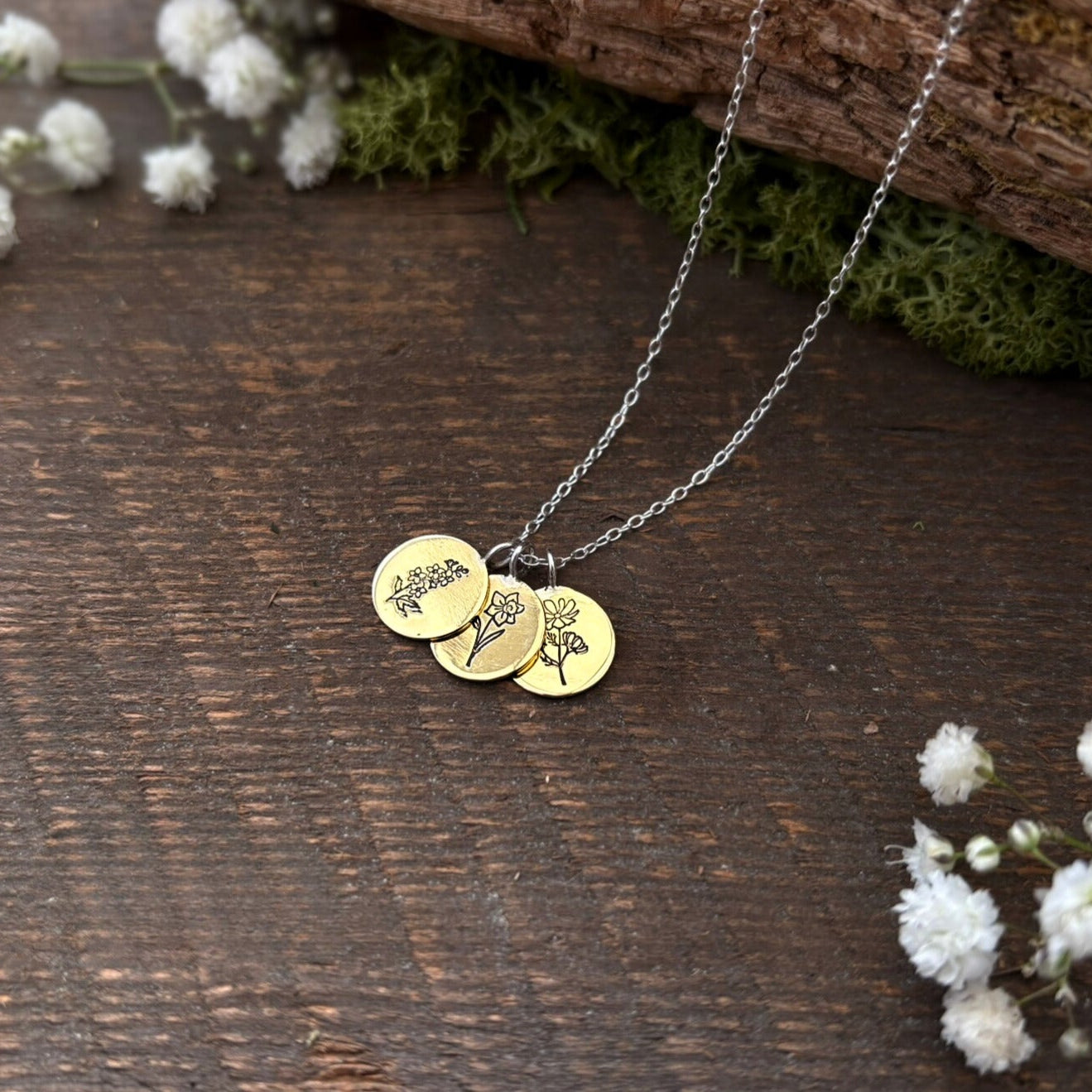 Brass birth flower bouquet necklace by curious magpie jewellery featuring charms on a necklace with engraved birth flowers on each charm.