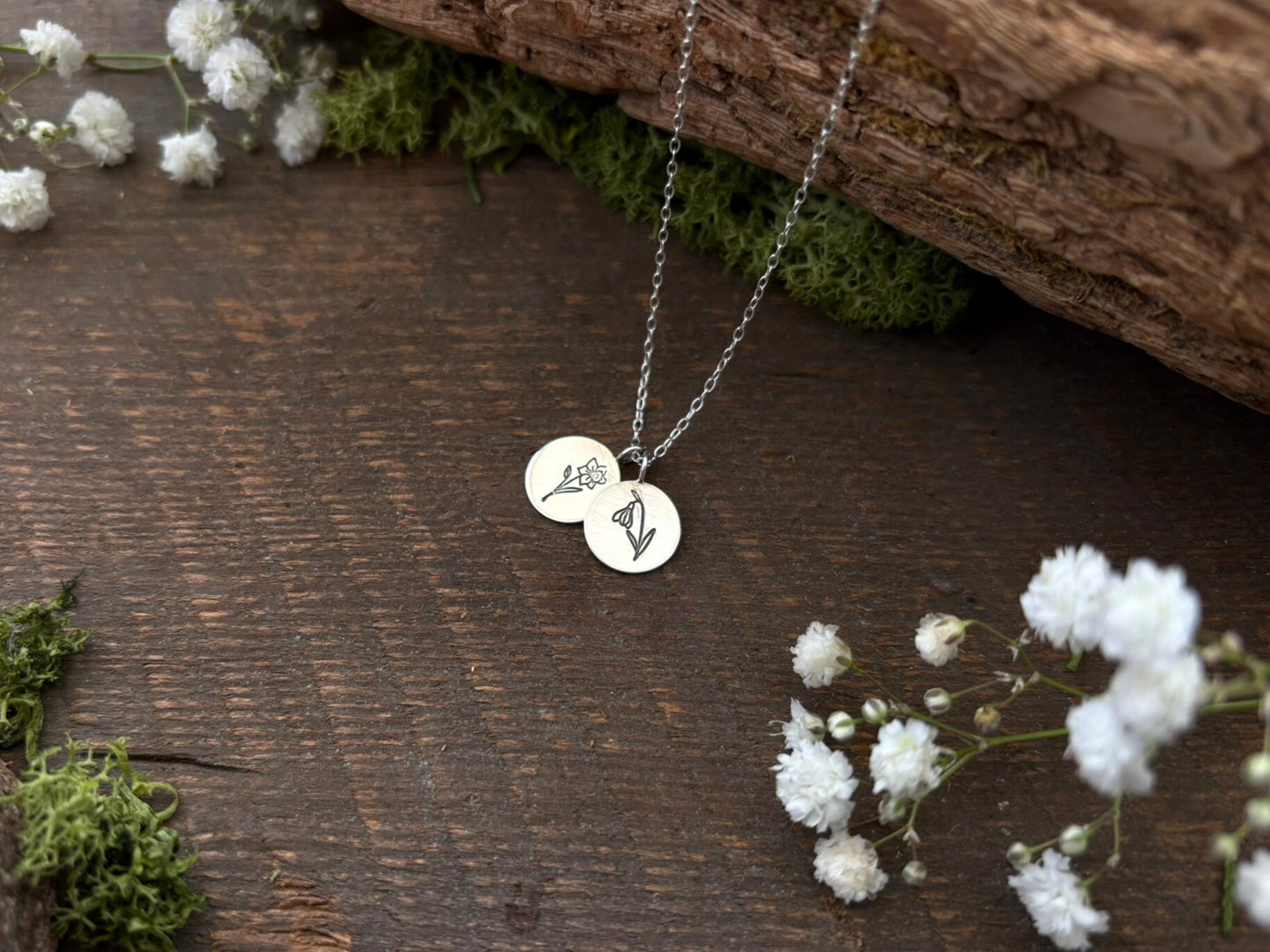 Sterling silver birth flower bouquet necklace by curious magpie jewellery featuring charms on a necklace with engraved birth flowers on each charm.