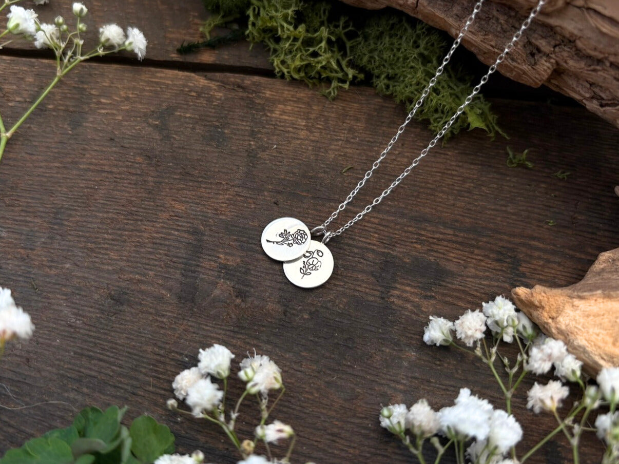 Sterling silver birth flower bouquet necklace by curious magpie jewellery featuring charms on a necklace with engraved birth flowers on each charm.