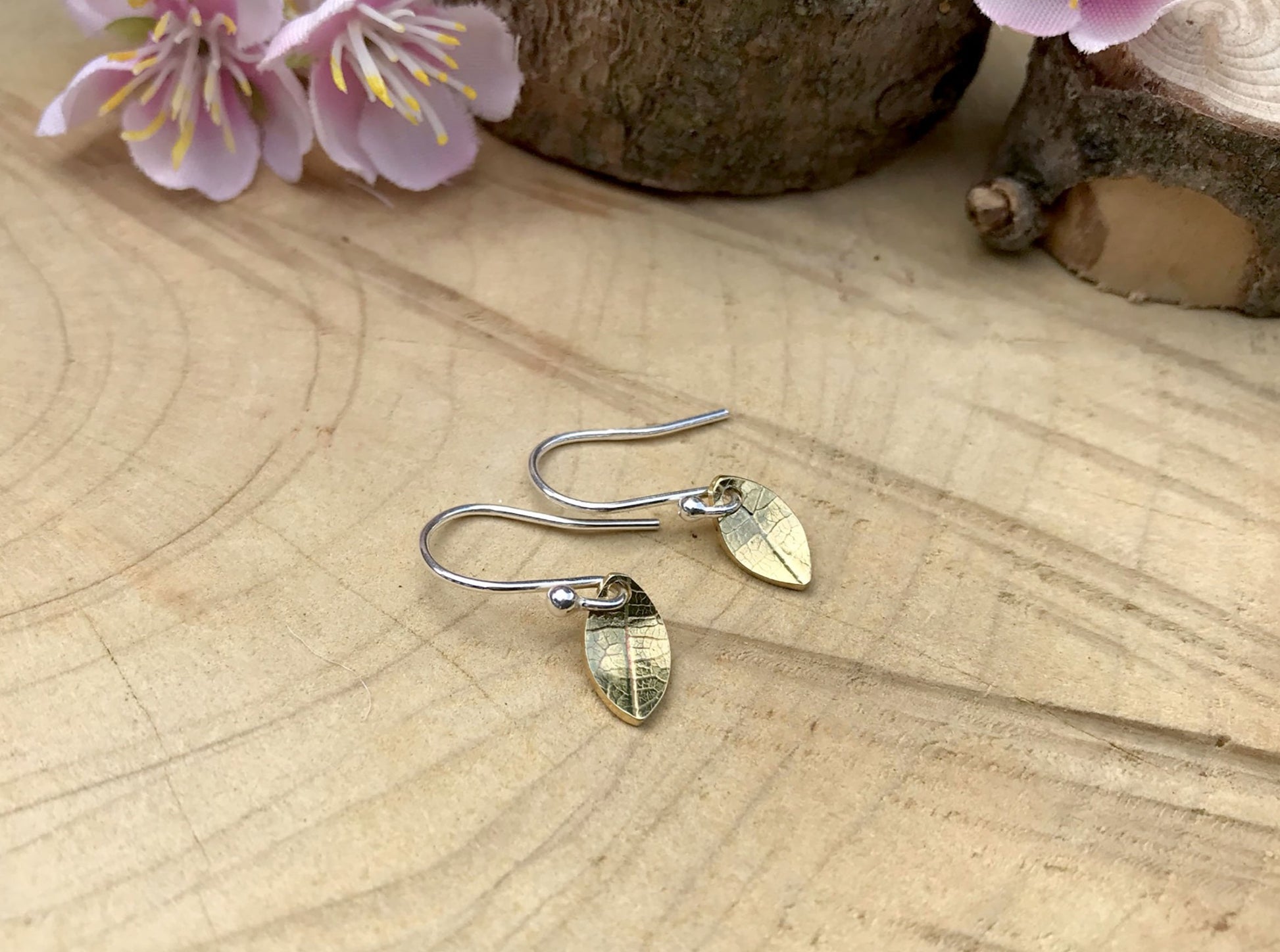 Silver hook earrings featuring tiny gold leaves by Curious Magpie Jewellery