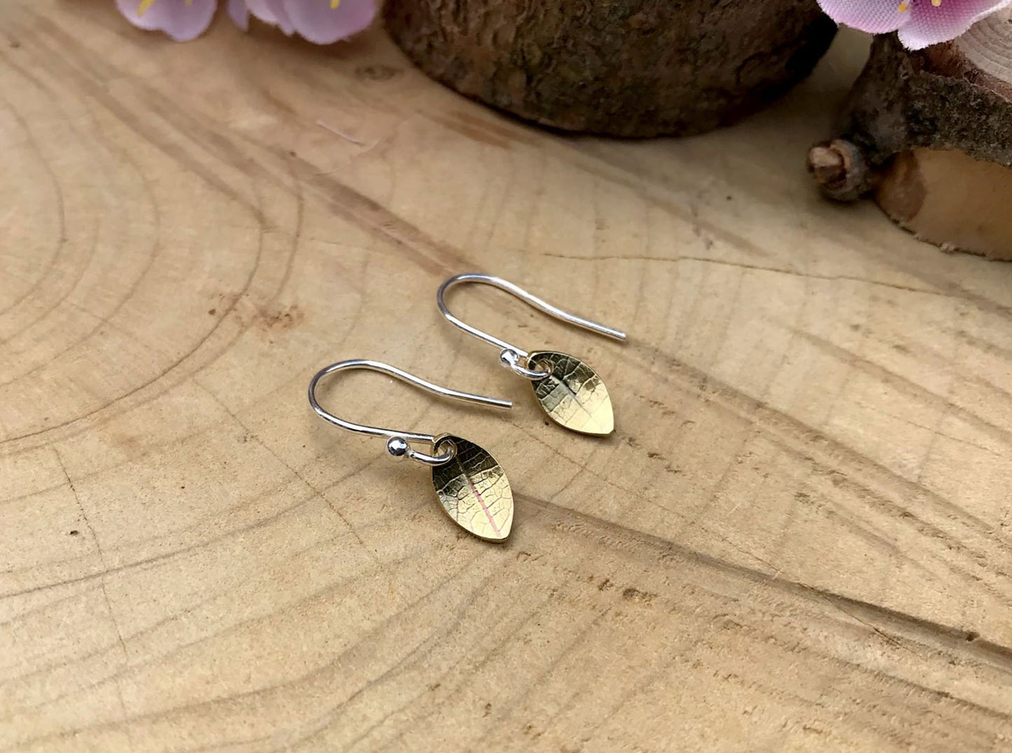 Silver hook earrings featuring tiny gold leaves by Curious Magpie Jewellery