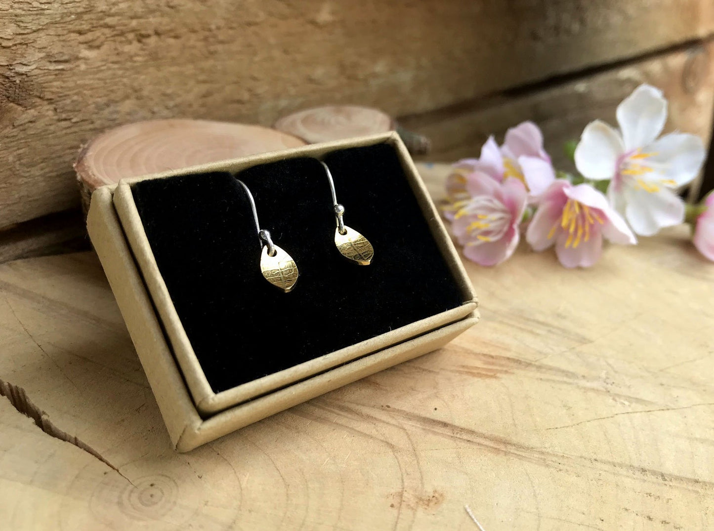 Silver hook earrings featuring tiny gold leaves by Curious Magpie Jewellery