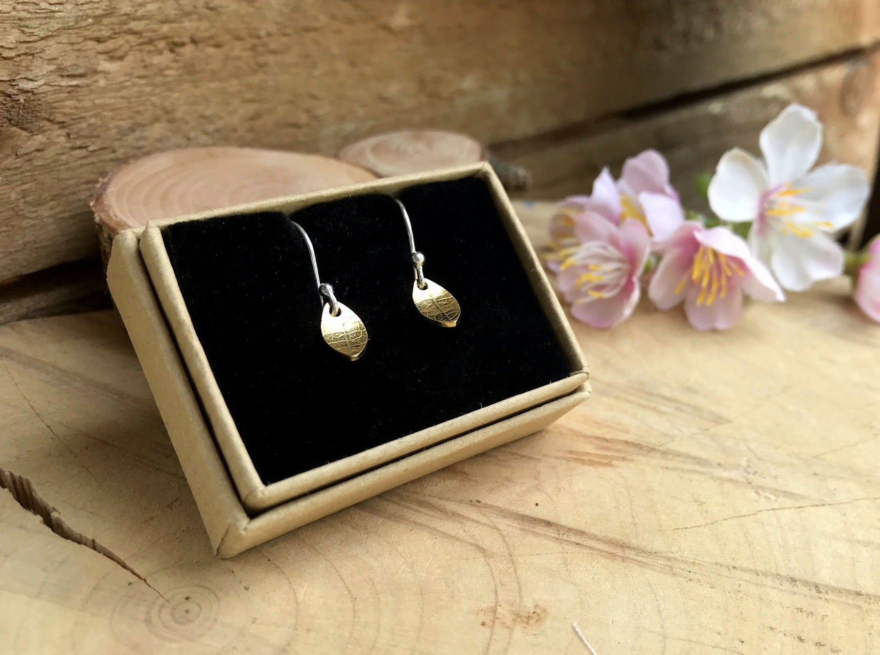 Silver hook earrings featuring tiny gold leaves by Curious Magpie Jewellery