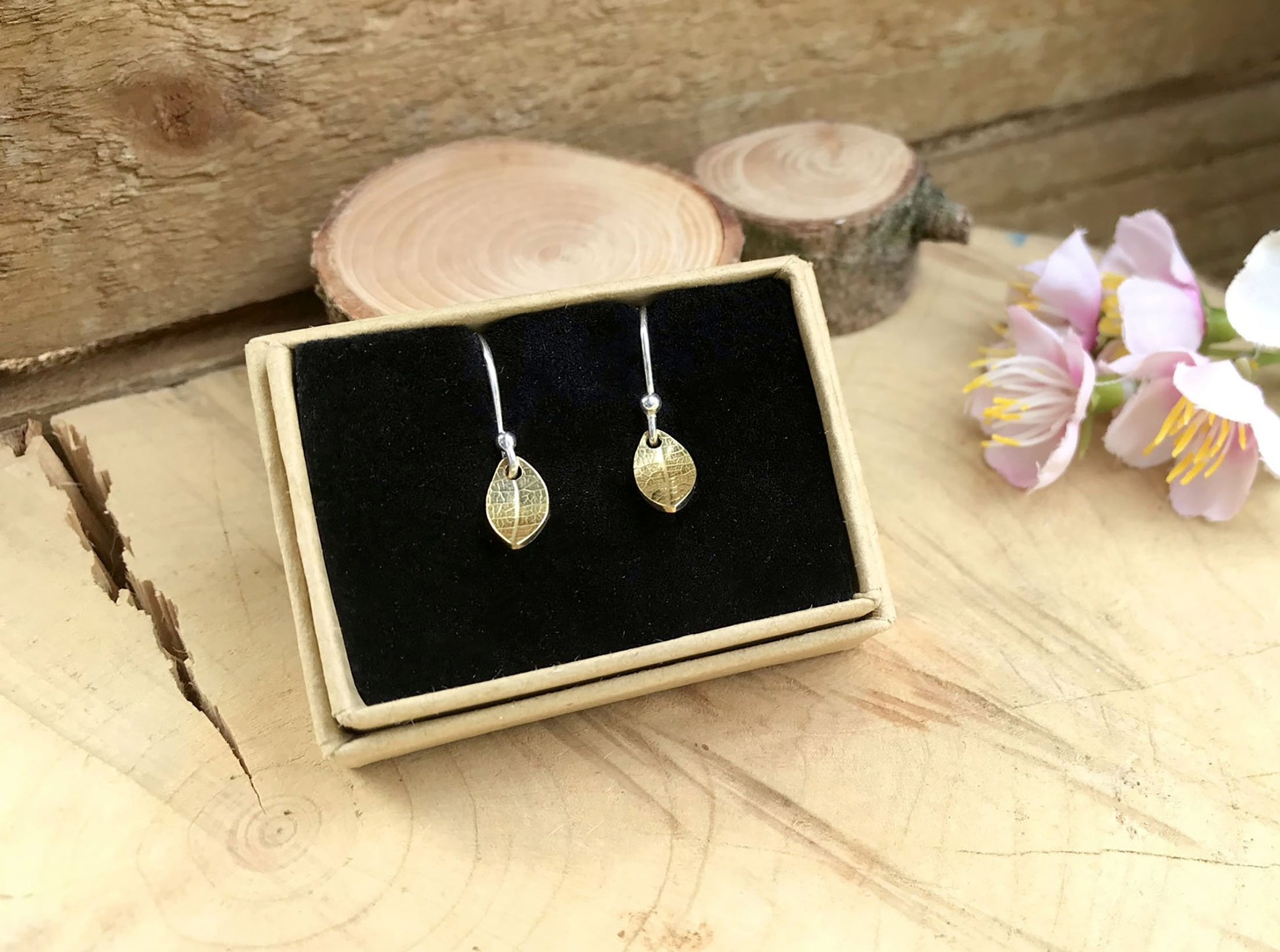 Silver hook earrings featuring tiny gold leaves by Curious Magpie Jewellery